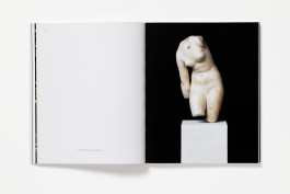 A spread from The Classical Now showing a blank left page with artwork details, and a large photograph of a first-century AD marble sculpture of Venus on a white pedestal, against a black background, on the right.
