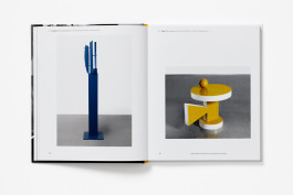 A spread from the Kim Lim book showing a tall blue abstract sculpture on the left, and a yellow and white abstract sculpture with geometric shapes on the right.