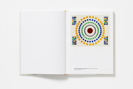 An open art book displaying a colourful, concentric circular diagram by Stephen Willats on the right-hand page.