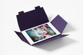 A deep purple exhibition box for Flora Yukhnovich and François Boucher, fully open to reveal a colourful abstract postcard with swirling pink, blue, and green forms.