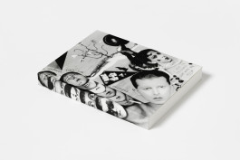 The Claude Cahun: Cancelled Confessions book is angled to show its front cover and spine, without the dust jacket, featuring a black and white collage artwork by Claude Cahun with faces, figures, and text.